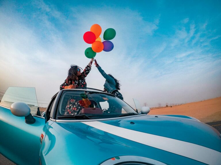 two women holding assorted color balloon lot