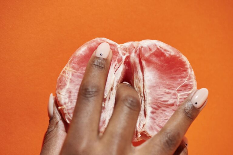 person holding red peeled grapefruit